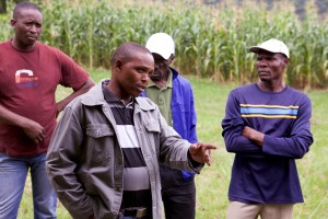 Sakhile enthusiastically discusses his thoughts with other men from the community.
